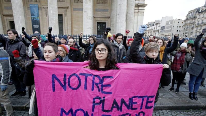 An environmental activist displays a placard as she protests at Pantheon monument in support of the Paris climate accord, in Paris PICTURE: Michel Euler/AP 