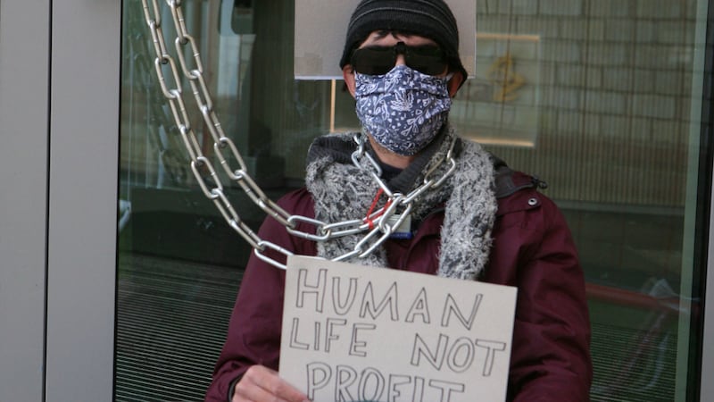 A protester chained himself to the door at the pharmaceutical firm’s Cambridge headquarters.