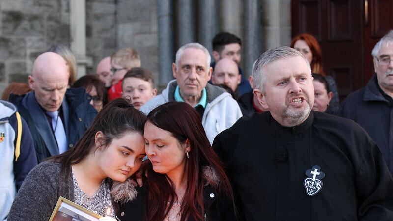 Joanne McGibbon (centre) with her daughter Seana and Father Gary Donegan at the candlelit vigil in Holy Cross Church. Picture by Philip Walsh