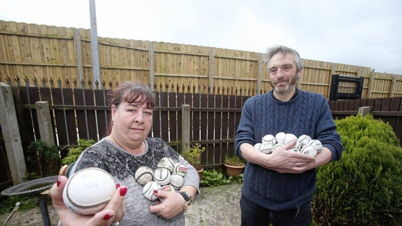 Corrib Avenue residents Caroline Mullan and Stephen McCartney with some of the hurling balls that land in their garden from the nearby St Pauls GAA Club. 
