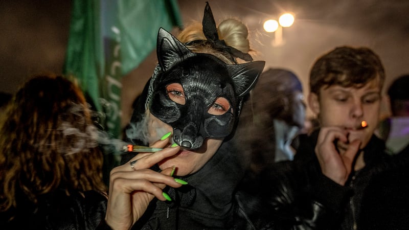People smoke cannabis in front of the Brandenburg Gate (Ebrahim Noroozi/AP)