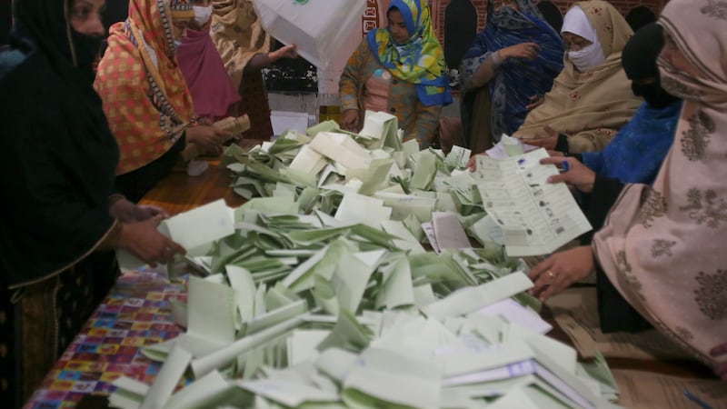 Members of polling staff count the votes after the polls closed for parliamentary elections, in Peshawar, Pakistan (Muhammad Sajjad/AP)