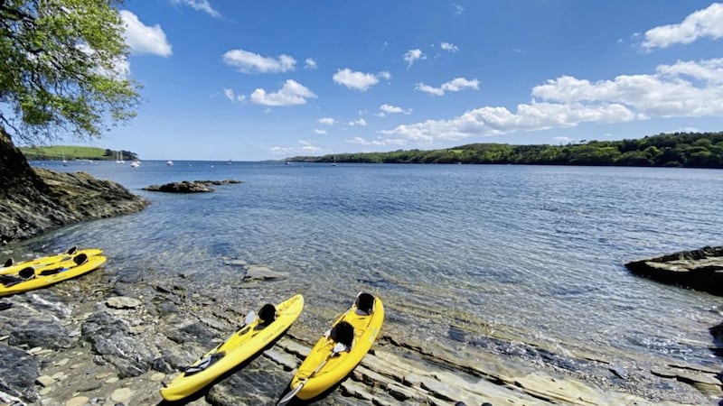 Kayaks at the side of the Helford River during a guided adventure with Koru Kayaking 