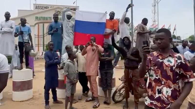 Supporters of mutinous soldiers hold up a Russian flag as they demonstrate in Niamey, Niger (Sam Mednick/AP)
