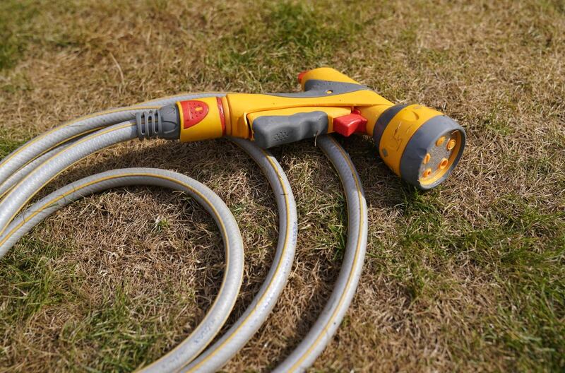 A hosepipe lies on a patch of scorched grass in Basingstoke, Hampshire