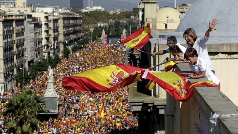 People on a rooftop wave Spanish flags during a march in downtown Barcelona on Sunday to protest against the Catalan government&#39;s push for secession from the rest of Spain PICTURE: Manu Fernandez/AP 