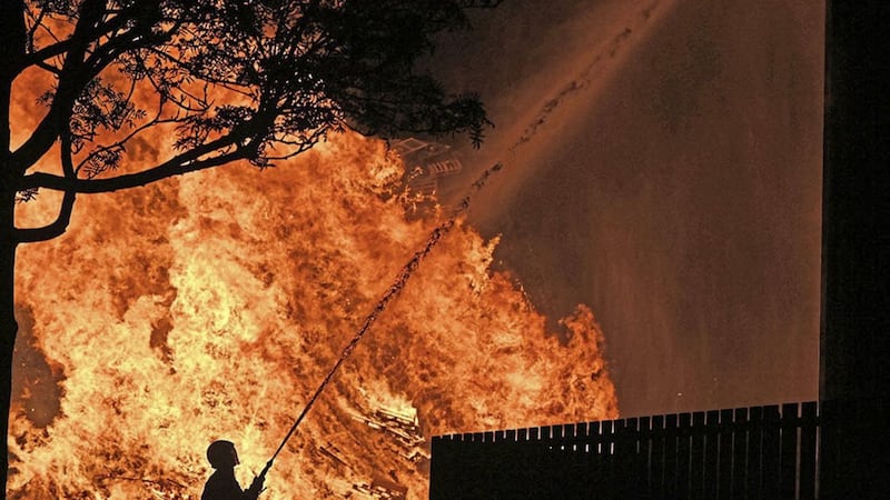 Firefighters protect houses from the bonfire at Corcrain estate in Portadown last July. Picture: Pacemaker. 