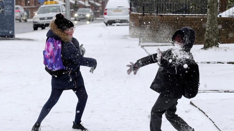 School children in west Belfast play in the snow on the way to school Picture Mal McCann. 