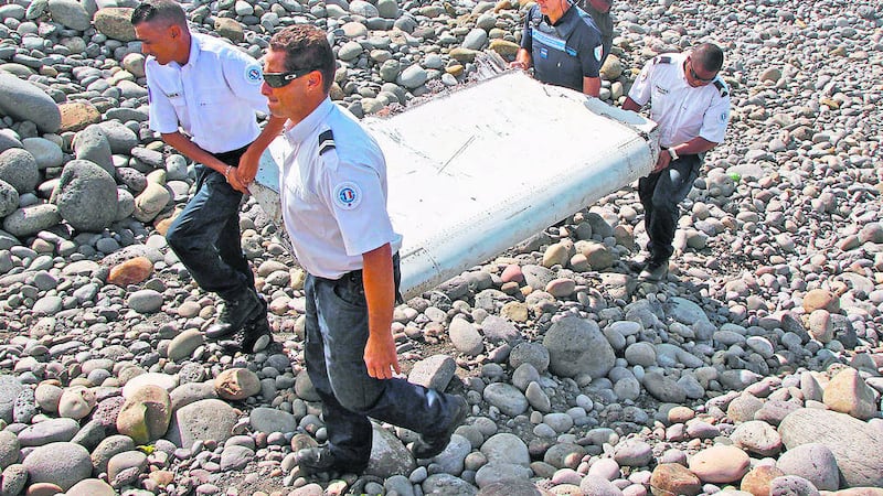 FILE - In this July 29, 2015 file photo, French police officers carry a piece of debris from a plane in Saint-Andre, Reunion Island. Experts have confirmed that the debris was that of Malaysian Airlines flight 370 that went missing last year, Malaysia's prime minister said early Thursday.  (AP Photo/Lucas Marie, File).