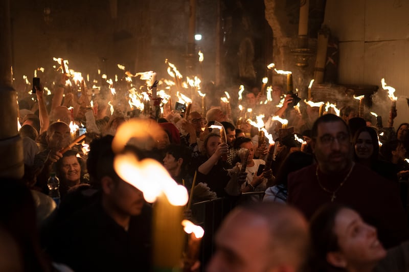 Christian Orthodox pilgrims hold candles during the ceremony (AP)