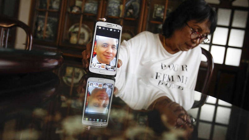 Sakinab Shah, sister of Captain Zaharie Ahmad Shahn holds up a picture of her brother. Nearly two years after the loss of Flight 370 she says her family must cope not only with his loss but with the theory that he was to blame. Picture by AP Photo/Joshua Paul 