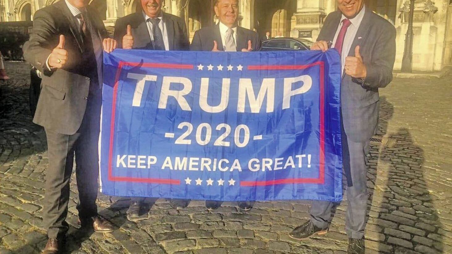 DUP MPs Sammy Wilson, Ian Paisley and Paul Girvan hold a flag supporting Donald Trump in the 2020 US presidential election 