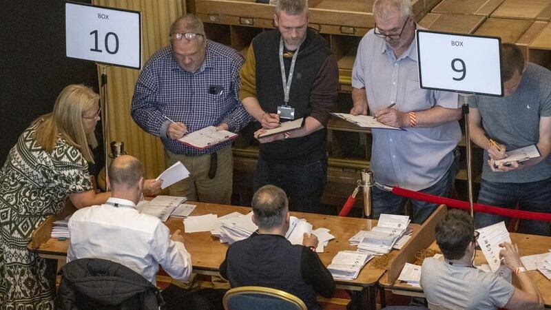 Green Party Northern Ireland leader Mal O’Hara, centre, tallying ballots as ballot boxes are opened in Belfast City Hall. Picture by Liam McBurney/PA