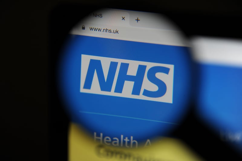 2BF034G The NHS website seen through a magnifying glass on a computer