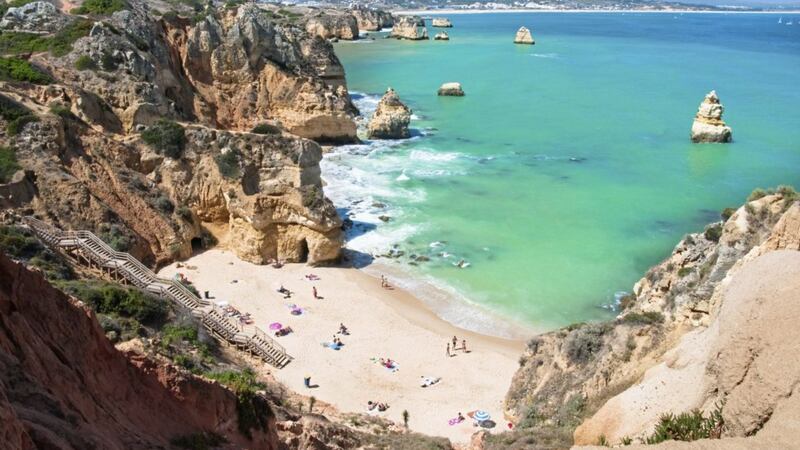 A sunny beach located between the sandstone cliffs of Ponta da Piedade near Lagos - Algarve, Portugal 