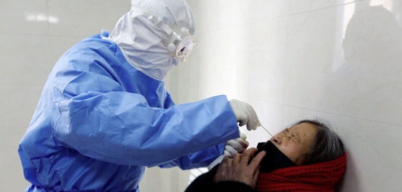 A doctor takes a swab from a woman to test for the Covid-19 virus in China 