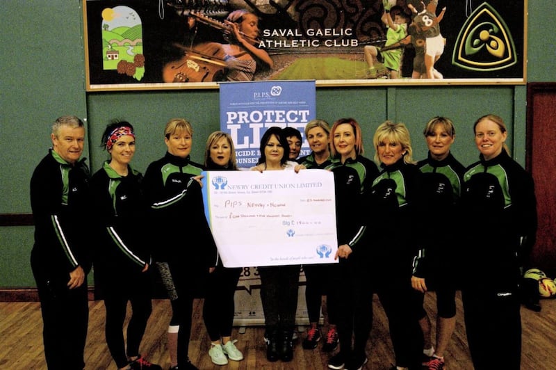 Thelma Thompson from PIPS Newry &amp; Mourne receives a cheque for &pound;1,580 from the Saval Gaelic4Mothers and Others football team. Funds were raised at a recent ABBA charity night in support of the leading suicide prevention charity in the area 