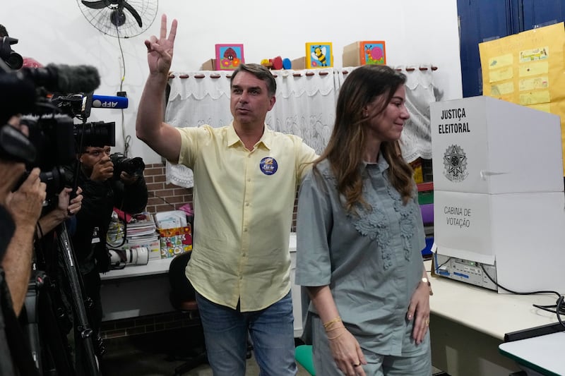 Opposition presidential candidate Flavio Bolsonaro makes a victory sign after voting in Rio de Janeiro (Silvia Izquierdo/AP)