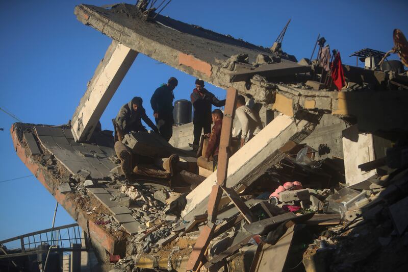 Palestinians inspect the damage of a destroyed house following Israeli air strikes on Khan Younis (AP)