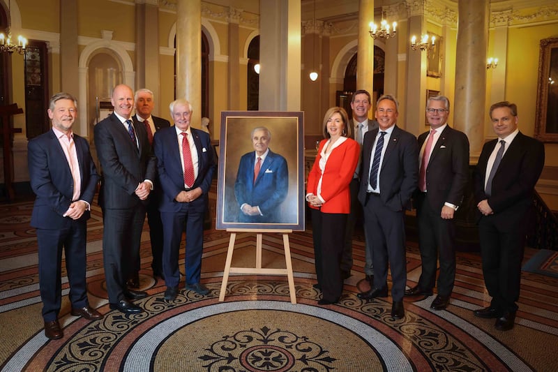 Group photo of nine people gathered around the new portrait of Dan Sten Olsen in Belfast Harbour's offices.