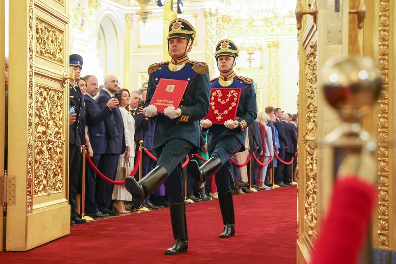 Honour guards of the Presidential regiment carry a special copy of the Russian Constitution and the President’s Badge (Alexander Kazakov/AP)