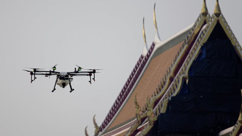 Drone pilots fly a water-spraying drone over the Suthat Temple in Bangkok, Thailand Picture by Sakchai Lalit/AP 
