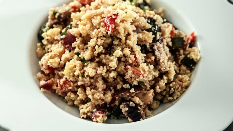 Roasted vegetabes with couscous in a white bowl.