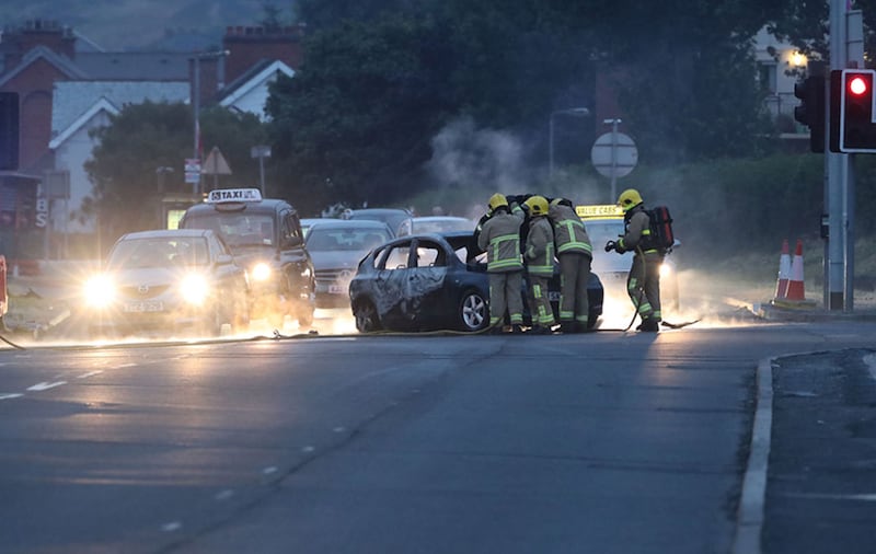 Firefighters deal with a burnt out car in the Cherryhill area of Dundonald in east Belfast&nbsp;