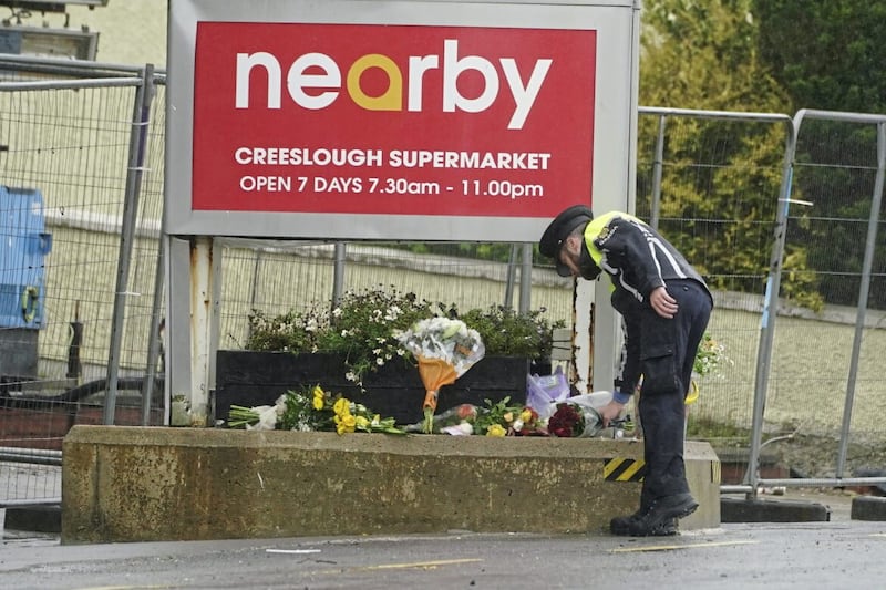 A member of An Garda lays flowers to the scene of an explosion at Applegreen service station in the village of Creeslough in Co Donegal on Sunday. Picture by PA