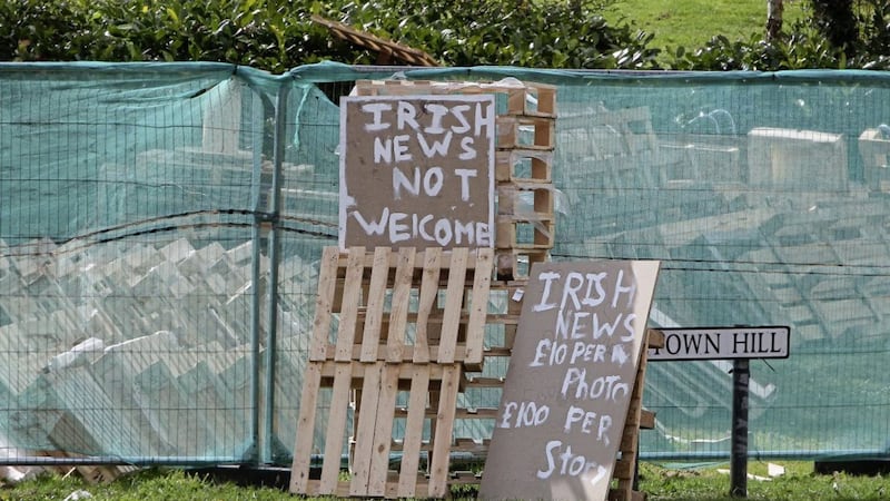 An &#39;Irish News not welcome&#39; sign beside a bonfire site at Milltown Hill in south Belfast 