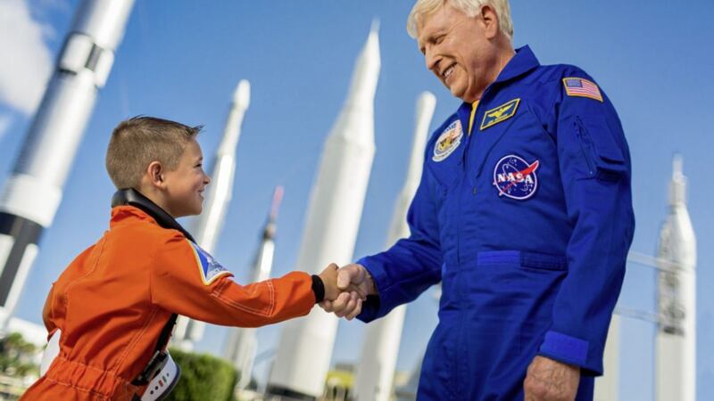 Veteran astronaut Jon McBride meets a young visitor at the Kennedy Space Center 