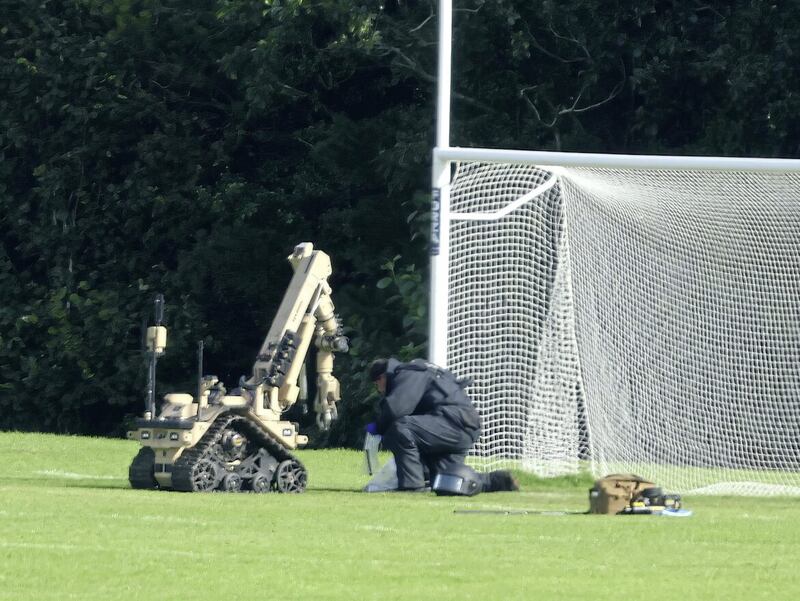 A bomb disposal officer examines a suspected pipe bomb device left playing fields used by East Belfast GAA - an all-too-familiar scene  Picture: Mal McCann. 