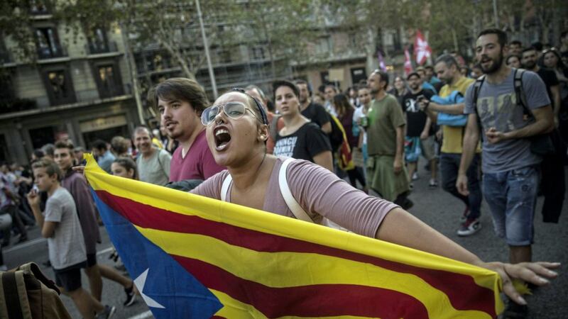 A woman carries an independence Catalan flag as demonstrators march downtown Barcelona last week 