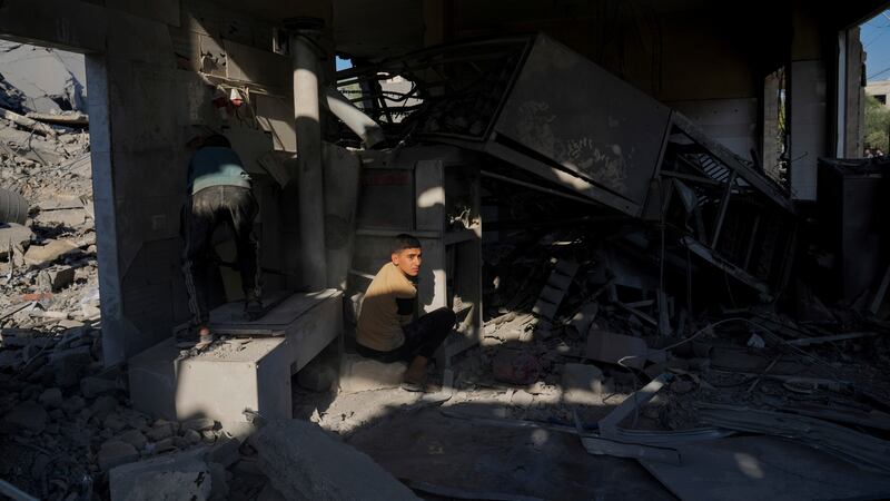 Palestinians inspect a house after it was hit by an Israeli airstrike in Deir al Balah, Gaza (AP)