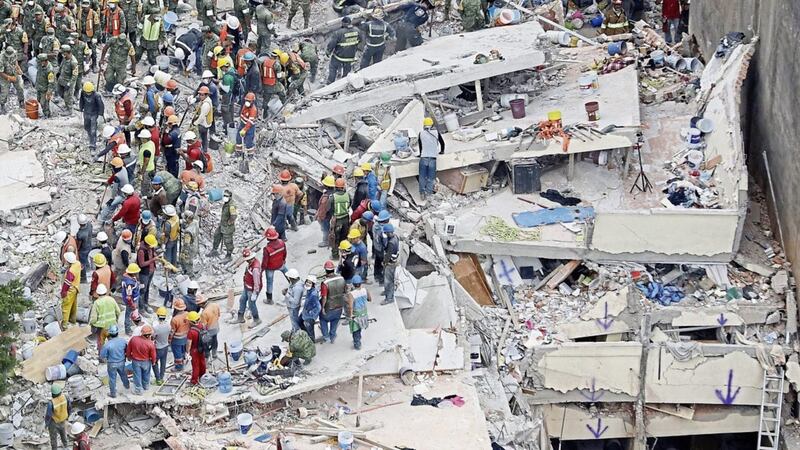 Rescue workers search for people trapped inside a collapsed building in the Del Valle area of Mexico City PICTURE: Rebecca Blackwell/AP 