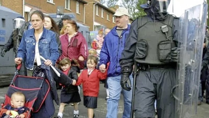 Shannon Rock (in red cardigan) pictured walking to school during the Holy Cross dispute in 2001 with her mother, Nichola Bradley and younger brother, Sean in pram 