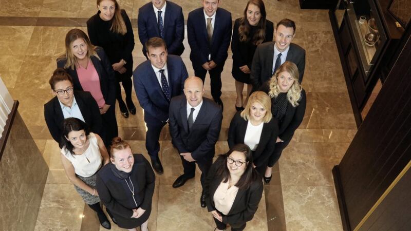 Patrick Brown (centre), managing partner, Tughans, welcomes director Graham Ord (centre left) and 12 new legal executives, associate and trainee solicitors. 