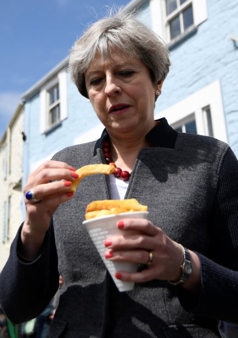 Theresa May having some chips (Dylan Martinez/PA)