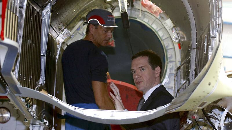 CRITICISM: Chancellor of the Exchequer George Osborne, right, looks inside the engine casing of a Eurofighter Typhoon fighter jet during his visit to BAE Systems in Warton, Lancashire, as Mr Osborne denied Labour claims that he was &lsquo;pulling the rug&rsquo; from underneath thousands of families, insisting a radical reform package which took an axe to tax credits while dramatically increasing the minimum wage was part of a &lsquo;new contract&rsquo; PICTURE:  Andrew Yates/PA 