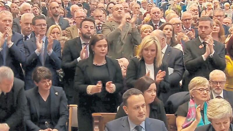 A videograb from BBC footage shows politicians at Lyra McKee's funeral gradually joining mourners in a standing ovation