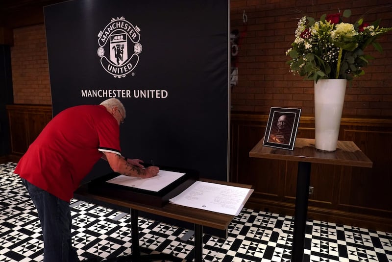 Manchester United fan Stanley Livesey signs the book of condolence for Sir Bobby Charlton