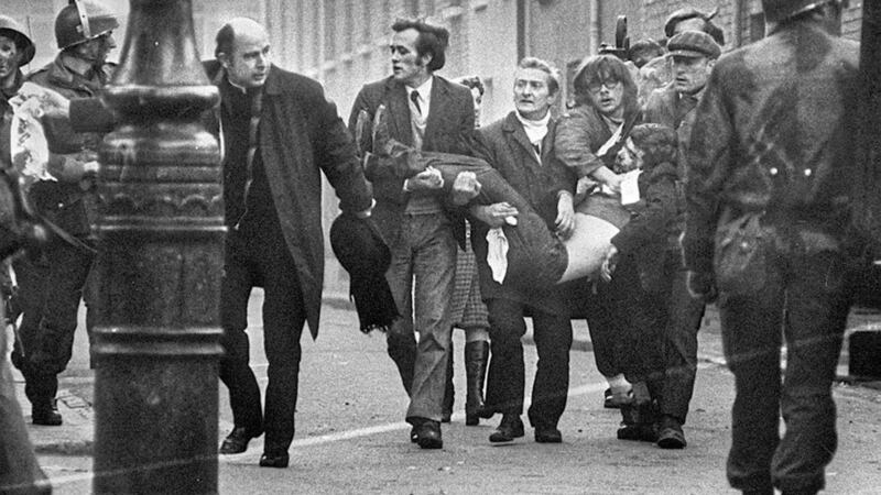 Bishop Daly helps clear a path for a man badly injured during Bloody Sunday which marks its 50th anniversary on January 30. 