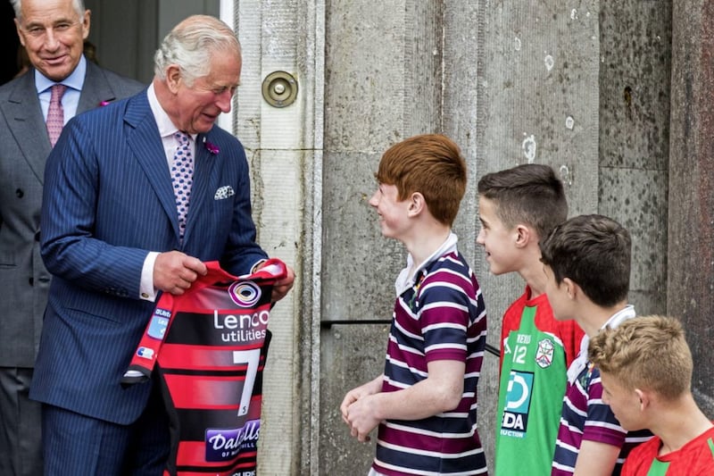 The Prince of Wales speaks to pupil Lloyd Quinn from The Royal School, Armagh, after being presented with an Ulster rugby jersey following an engagement at Palace Demense in Co Armagh PICTURE: Liam McBurney/PA 