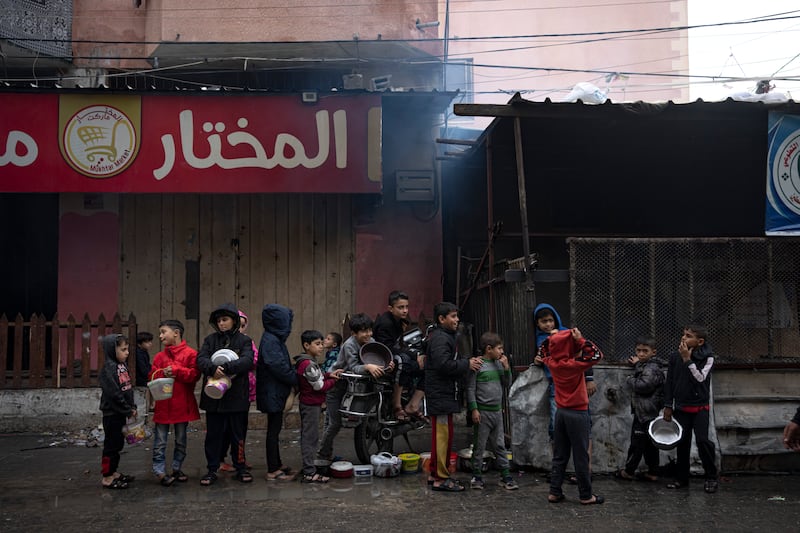 Palestinian children wait in line for food distribution in Rafah (Fatima Shbair/AP)