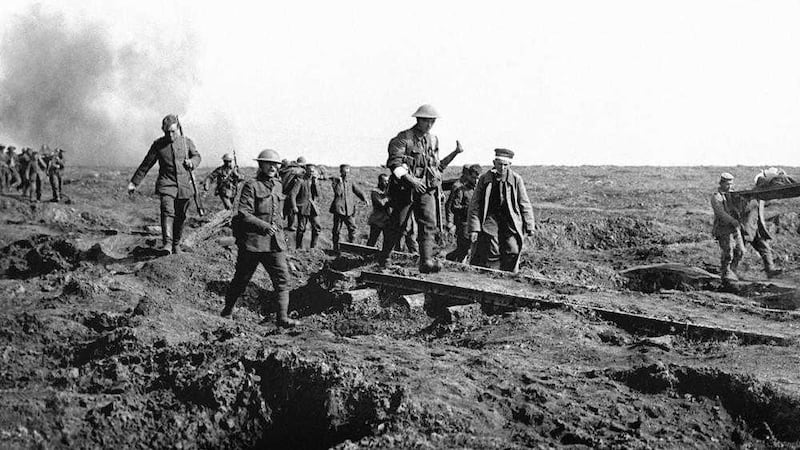 German prisoners help to carry British wounded back to their trenches after an attack by XIV (Irish) Corps on Bavarian units holding Ginchy during the Battle of the Somme. 