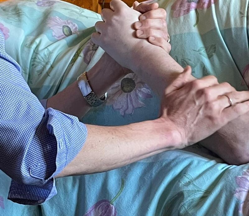 Rob Walker holding Stephen Isles' hand on his death bed