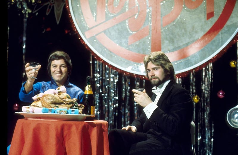 Tony Blackburn and Noel Edmonds, former presenters of the Radio 1 Breakfast Show, on the Christmas edition of Top Of The Pops in 1976. (Image: PA)