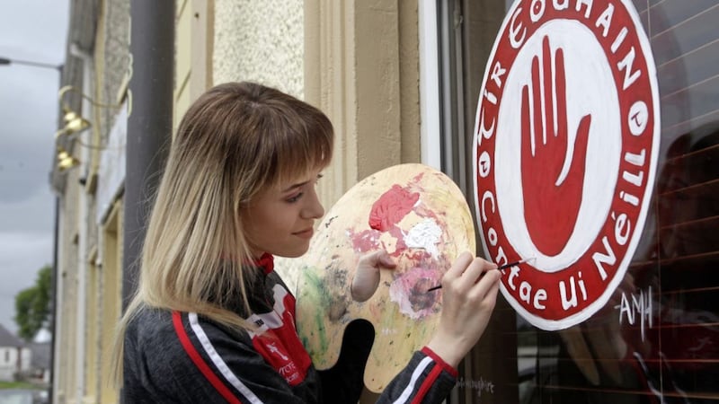 Aoife McHugh paints the Tyrone badge on the window of the Shepherd&#39;s Inn, Killeter, Co Tyrone. Picture by Ann McManus 