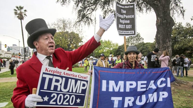 A supporter of US president Donald Trump holds a sign during a rally against a visit by Mr Trump in Beverly Hills, California Picture by Ringo HW Chiu/AP 
