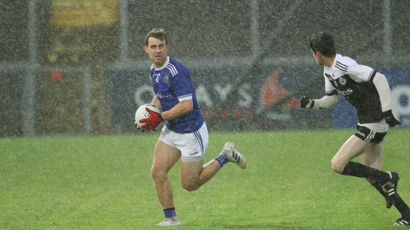 &nbsp;Warrenpoint's John Boyle strides away from Kilcoo's Eugene Branagan. Picture by Louis McNally